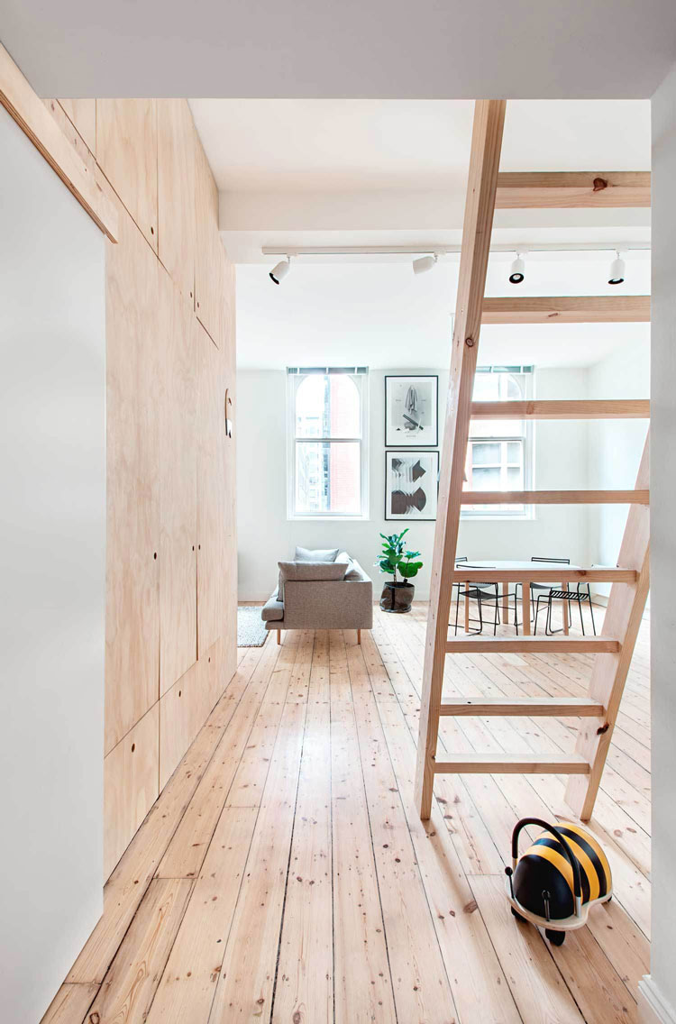 Flinders Lane Space Efficient Apartment open plan living area steps lead to an upstairs mezzanine for guests